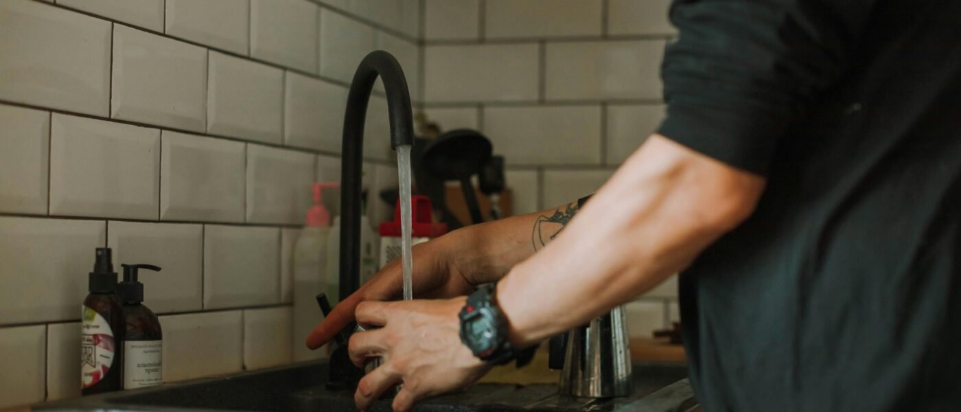 Man getting water from faucet